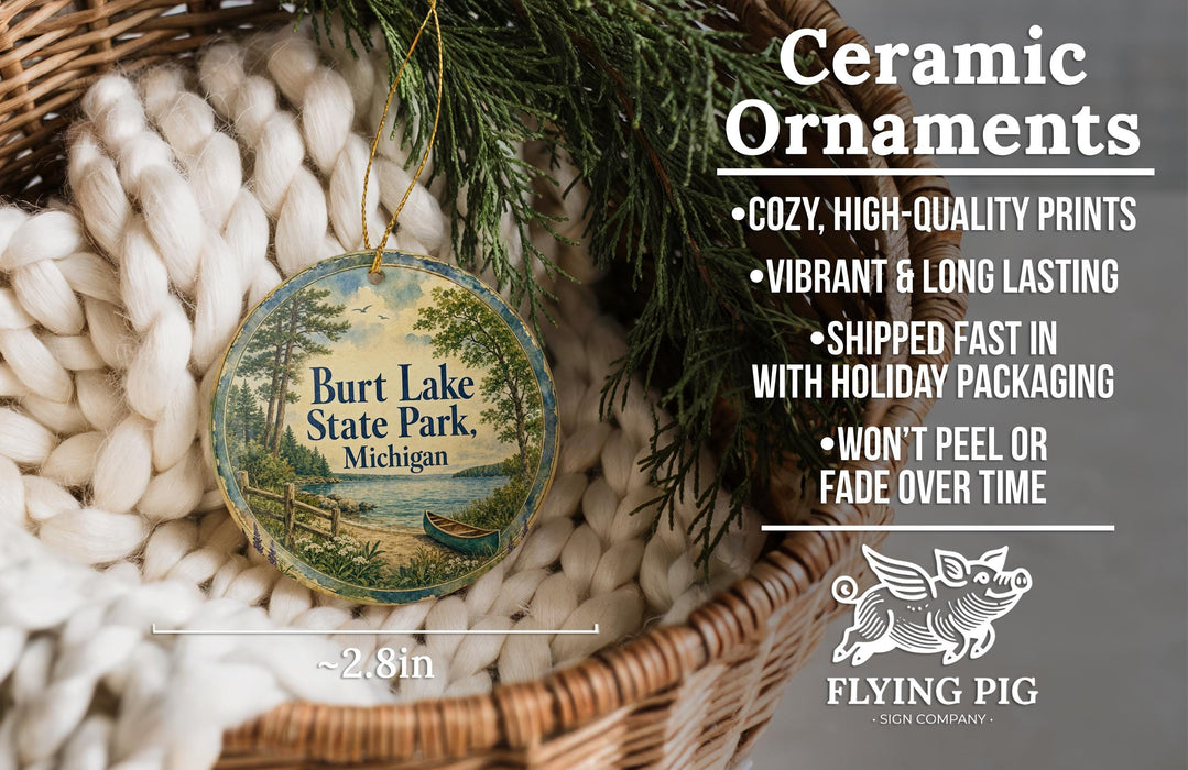 Ceramic ornaments, featuring a round ornament with a scenic image of Burt Lake State Park, Michigan, hanging from a wicker basket.