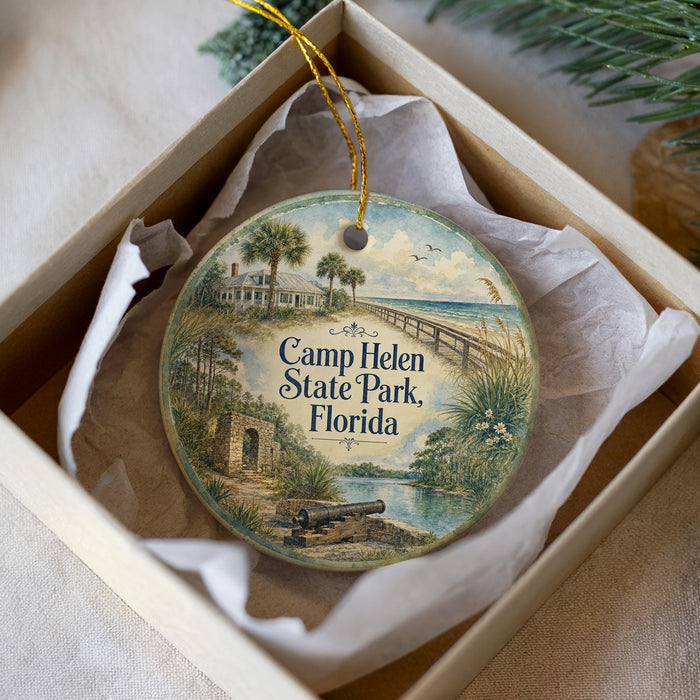 A round ornament with a painting of a beach and palm trees, featuring the text "Camp Helen State Park, Florida" on it.