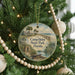 A round ornament hanging on a Christmas tree, featuring a scenic image of Camp Helen State Park in Florida.