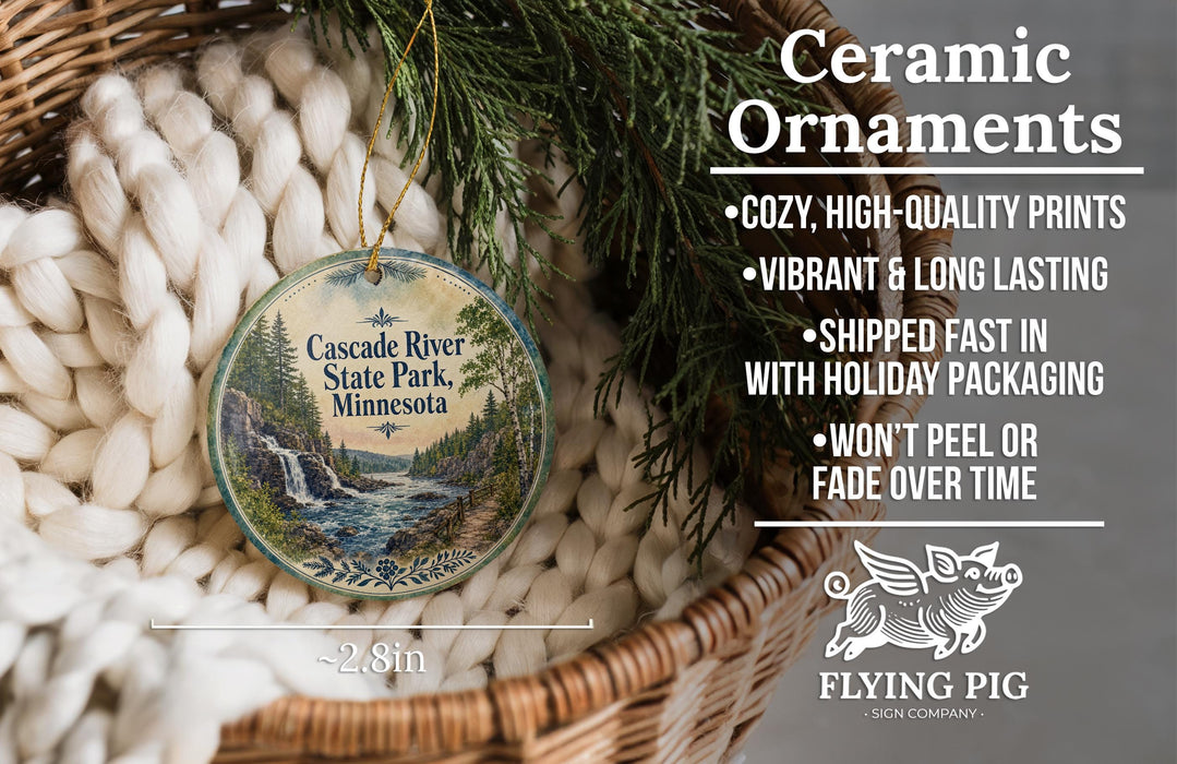 Ceramic ornaments, featuring a scenic image of the Cascade River State Park in Minnesota, are displayed in a woven basket.