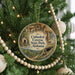 A circular ornament hanging on a Christmas tree, featuring an illustration of the Cathedral Caves State Park in Alabama.