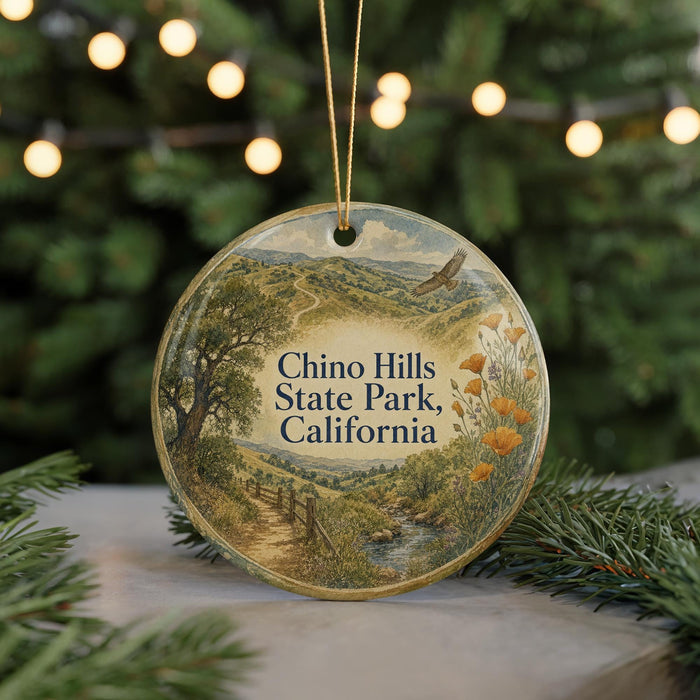 A round ornament with a scenic landscape of hills, trees, and a winding path, featuring the text "Chino Hills State Park, California".