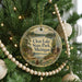 A Christmas tree decorated with ornaments, including a round ornament with a scenic image of Clear Lake State Park, Michigan.