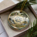 A decorative ornament in a box, featuring a scenic landscape with a waterfall and a castle, with the text "Clinton State Park, Kansas" prominently displayed.