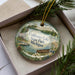 A decorative ornament with a lake scene and pine branches, featuring the text "Coldwater Lake State Park, Michigan" on it.