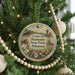 A round ornament hanging on a Christmas tree, featuring a scenic image of Crater of Diamonds State Park in Arkansas.