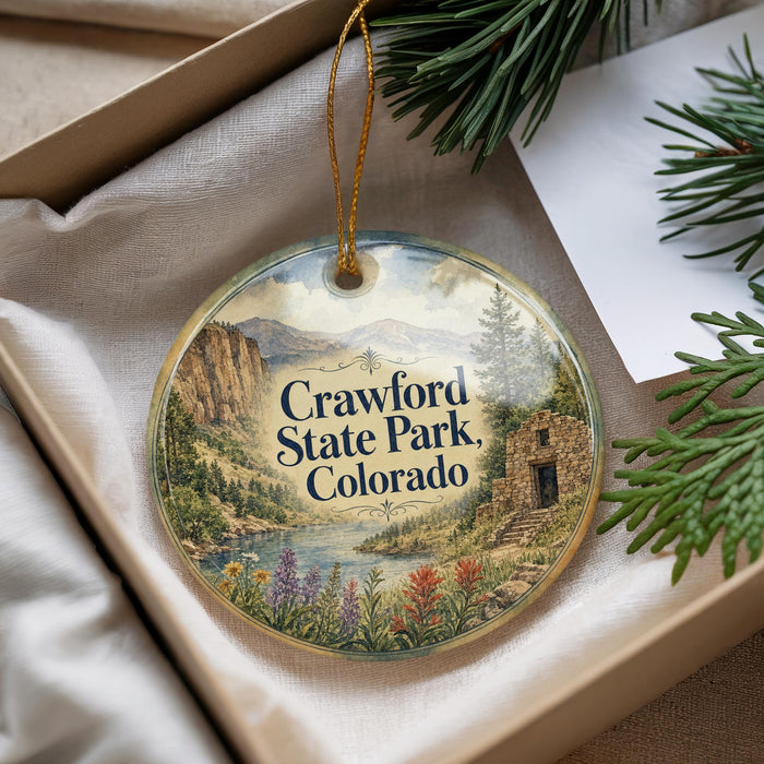 A decorative ornament with a scenic landscape of Crawford State Park, Colorado, featuring mountains, a river, and wildflowers.