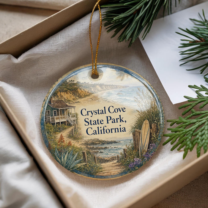 A decorative ornament with a beach scene and a house, featuring the text "Crystal Cove State Park, California" on it.