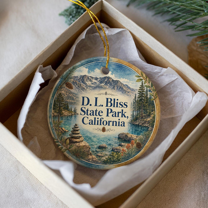 A decorative ornament with a scenic landscape of mountains, water, and pine trees, featuring the text "D. L. Bliss State Park, California".