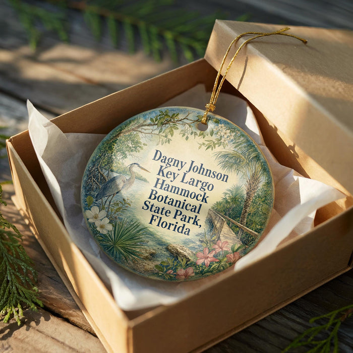 A decorative ornament in a cardboard box, featuring a tropical scene with a bird and flowers.