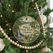A round ornament hanging on a Christmas tree, featuring a scenic image of Daisy State Park in Arkansas.