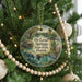A round ornament hanging on a Christmas tree, featuring a scenic image of De Leon Springs State Park in Florida.