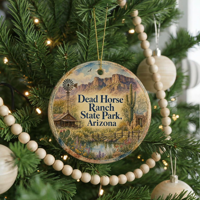 A round ornament hanging on a Christmas tree, featuring a scenic image of Dead Horse Ranch State Park, Arizona.