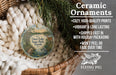 Ceramic ornaments, featuring a deer lake park ornament with a bird and a bridge, are displayed in a basket with greenery.