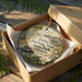 A decorative ornament in a wooden box, featuring a scenic illustration of Delta Heritage Trail State Park in Arkansas.