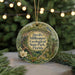 A round ornament with a floral design and text, hanging on a string.