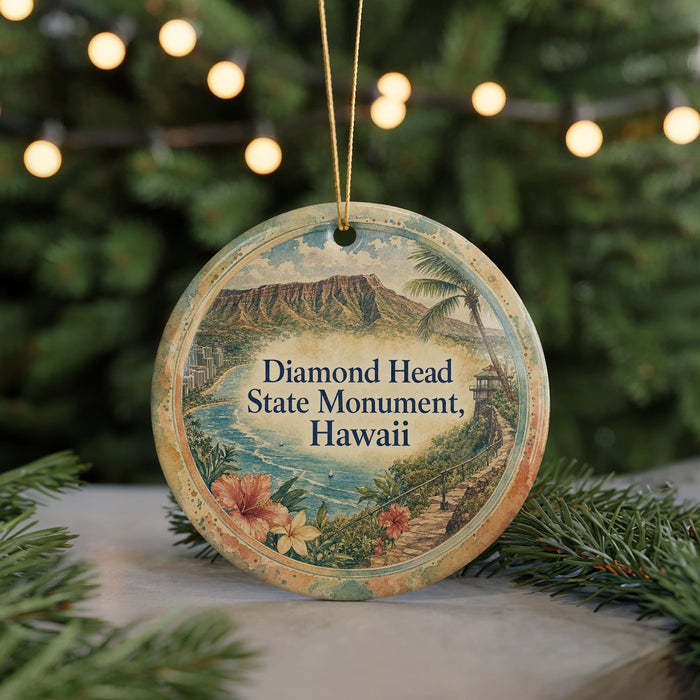 A round ornament with a scenic image of the Diamond Head State Monument in Hawaii, surrounded by greenery and twinkling lights.