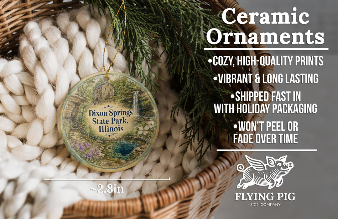 Ceramic ornaments, featuring a detailed image of Dixon Springs State Park in Illinois, are displayed in a woven basket. The text highlights the ornaments as "cozy, high-quality prints" and "vibrant and long lasting", with a description of their shipping speed and packaging. The image also includes a logo for "Flying Pig - SIGN COMPANY".