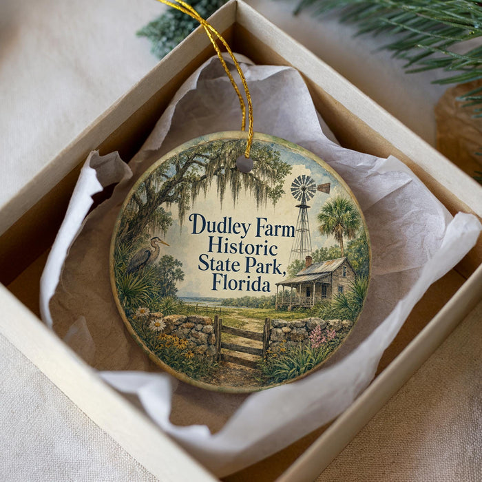 A decorative ornament in a white box, featuring a scenic image of Dudley Farm Historic State Park, Florida.