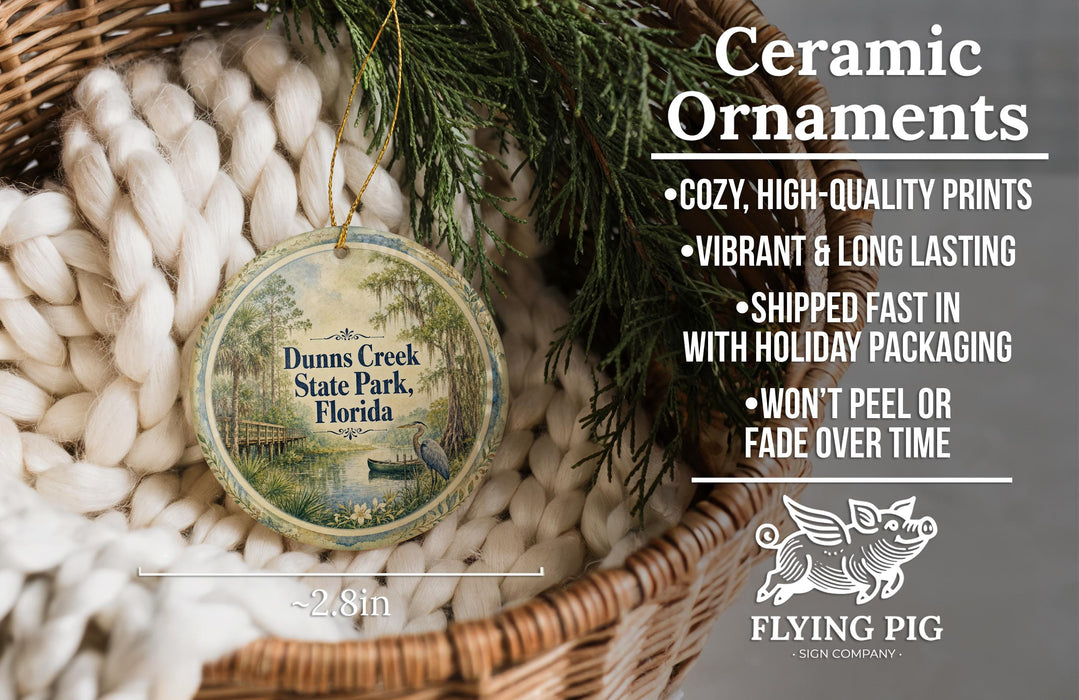Ceramic ornaments, featuring a round ornament with a scenic image of Dunns Creek State Park, Florida, hanging from a wicker basket.