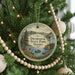 A round ornament hanging on a Christmas tree, featuring a scenic image of Dworshak State Park in Idaho.