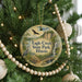 A round ornament hanging on a Christmas tree, featuring an illustration of a bird and a waterfall, with the text "Eagle Creek State Park, Illinois" displayed prominently.