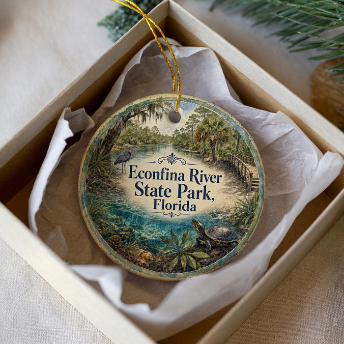 A circular ornament with a scenic image of the Econfina River State Park in Florida, featuring a bird, palm trees, and a bridge.