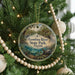 A circular ornament hanging on a Christmas tree, featuring a scenic image of the Econfina River State Park in Florida.