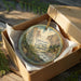 A decorative ornament in a box, featuring a scenic landscape of Eldorado Canyon State Park in Colorado.