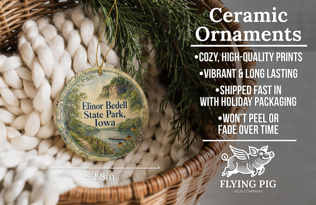 Ceramic ornaments, featuring a round ornament with a scenic landscape of Elinor Beddell State Park, Iowa, hanging from a wicker basket.