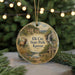 A round ornament with a scenic landscape featuring a deer, a waterfall, and a cabin, hanging on a string.