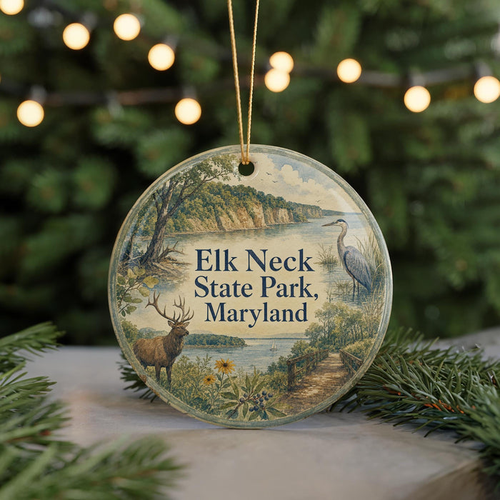 A round ornament with a scenic image of a deer, a bird, and a path in front of a body of water, with the text "Elk Neck State Park, Maryland" displayed on it.