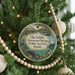 A round ornament hanging on a Christmas tree, featuring an illustration of a bird, a beaver, and a crocodile, with text that reads "Ellie Schiller Homosassa Springs Wildlife State Park, Florida".