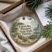 A round ornament with a bird and a seal, surrounded by greenery, is displayed in a box.
