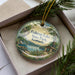A decorative ornament in a box, featuring a scenic image of Fish Trap Lake State Park, Kentucky.