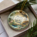 A decorative ornament with a scenic image of the Florida Caves State Park, featuring a cave, water, and greenery.
