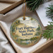 A round ornament with a picture of Fort Harrison State Park, Indiana, hanging from a string.