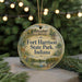 A round ornament with a picture of Fort Harrison State Park, Indiana, surrounded by greenery and a string of lights.