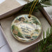 A decorative ornament in a box, featuring illustrations of Fort Massac State Park, Illinois.