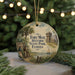 A round ornament with a painting of a historical scene, featuring a building, palm trees, and people, hanging on a string.