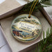 A decorative ornament in a box, featuring a painting of Fort Trumbull State Park in Connecticut.