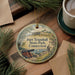 A round ornament with a painting of Fort Trumbull State Park, Connecticut, hanging on a wooden surface.
