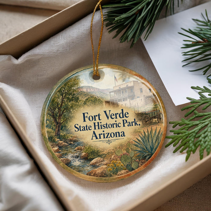 A round ornament with a scenic image of Fort Verde State Historic Park, Arizona, hanging from a string.