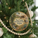 A round ornament hanging on a Christmas tree, featuring an illustration of Fort Verde State Historic Park in Arizona.