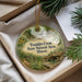 A round ornament with a scenic landscape of Franklin Creek, the State Natural Area in Illinois, displayed in a box with pine branches and a white card.