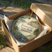 A decorative ornament in a box, featuring a scenic landscape of Frontenac State Park in Minnesota.