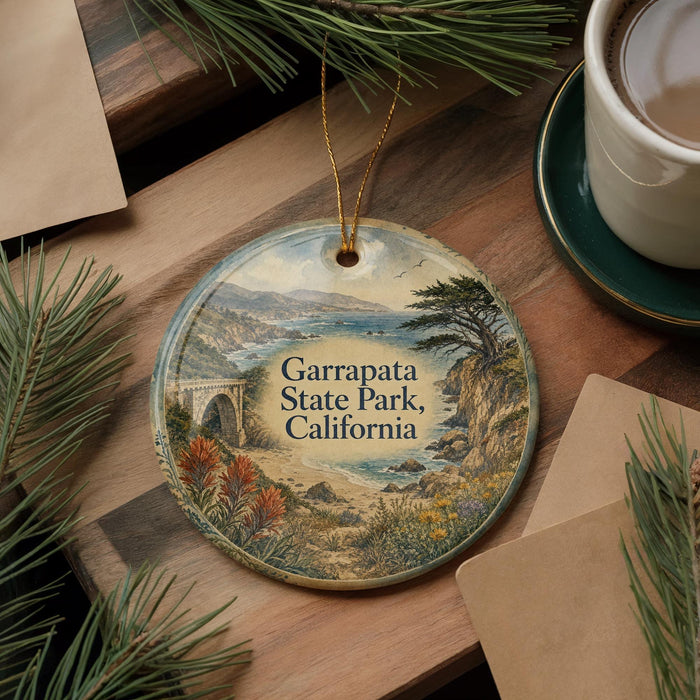 A decorative ornament featuring a scenic landscape of Garrapata State Park, California, with a bridge and pine trees.