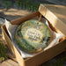 A decorative ornament in a brown box, featuring a scenic image of a waterfall and greenery, with the text "Giant City State Park, Illinois" printed on it.