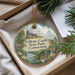 A decorative ornament with a castle and trees, featuring the text "Gillette Castle State Park, Connecticut" on it, is displayed in a box with pine branches.