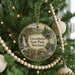 A round ornament hanging on a Christmas tree, featuring a scenic image of Greenbrier State Park, Maryland.